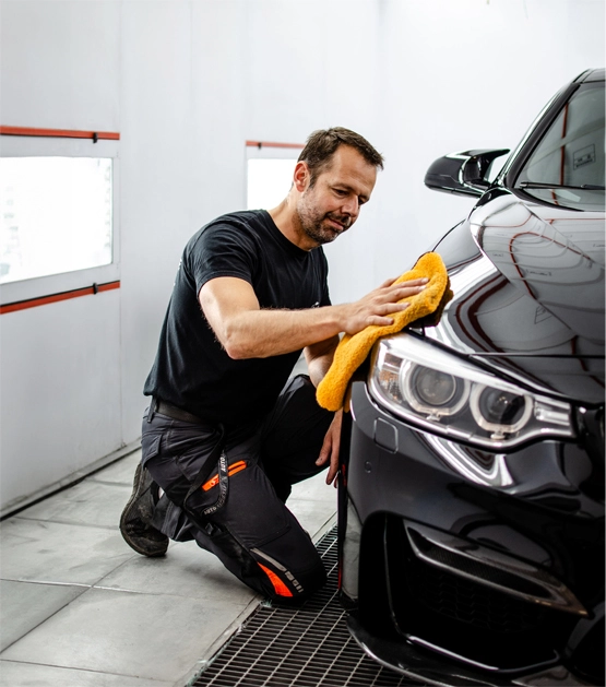 Le patron de la carrosserie effectuant les finitions sur un véhicule